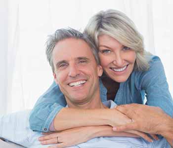 Couple smilling at the camera in home in living room